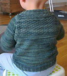 Hank knit child's cabled sweater with Malabrigo Merino Sock Yarn color aguas