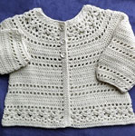 Hand-crocheted baby cardigan sweater with Malabrigo Merino Sock Yarn color natural
