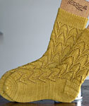 Hand-knit cabled socks made with Malabrigo Merino Sock Yarn color ochre