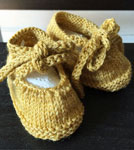 Hand-knit booties made with Malabrigo Merino Sock Yarn color ochre