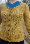 Hand-knit cabled cardigan sweater made with Malabrigo Merino Sock Yarn color ochre