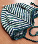 Hand-knit striped baby cap knit with Malabrigo Merino Sock Yarn colors solis and natural